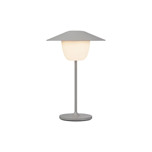 Moderne LED-lampe med konisk skærm og rund base, der udsender lys.