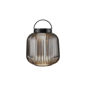 Sort LED-lampe med lodrette stænger og håndtag, designet af Blomus, bærbar og stilfuld.
