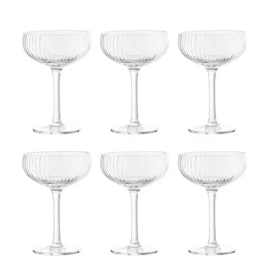 Seks klare champagneglas med ribbet design, arrangeret i to rækker á tre.