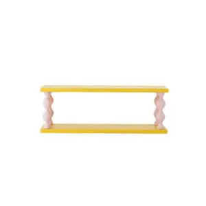 Gul hylde med snoede pink støtteben. Fra Bloomingville, model Bibiola Hylde i MDF.