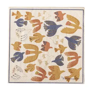 Serviet med farverige fugle i guld, blå og orange nuancer. "Bloomingville" branding synlig.