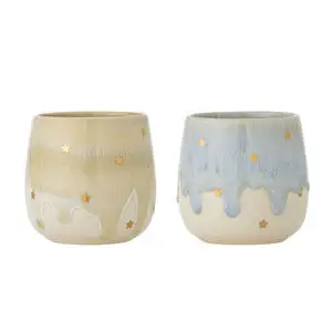 To runde kopper med dryppende glasur, beige/hvid og blå/hvid, med stjerneudsmykninger.