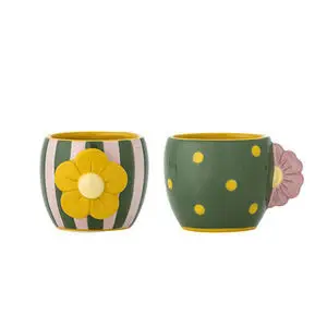 To kopper, en stribet med gul blomst og en med prikker og lyserød blomsterhank, begge med gul inderside.