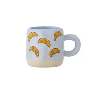 Lys blå kop med orange croissant-mønstre og stor rund hank, stabelbar.