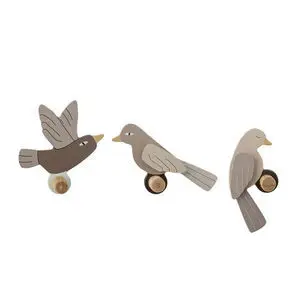 Tre fugleformede knager i forskellige farver på runde træbaser, med detaljerede vinger og haler.