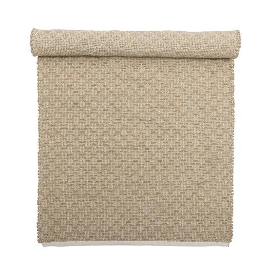 Rullet jute tæppe med tekstureret vævet mønster i naturlig beige farve.