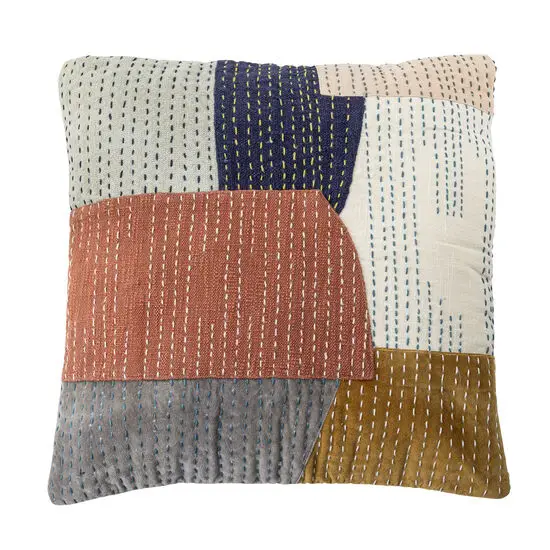 Pude med patchwork-design i orange, blå, grå, brun og beige, dekoreret med synlige syninger.