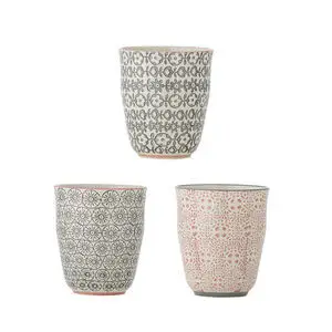 Tre kopper med unikke geometriske og blomsterdesign i grå, sort og lyserød fra Bloomingville.
