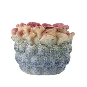 Urtepotteskjuler med blomsterlignende former, blå bund og lyserød top.