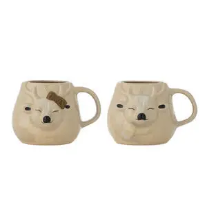 To beige rensdyrkrus i stentøj med detaljerede ansigtstræk og håndtag; én med brun sløjfe.