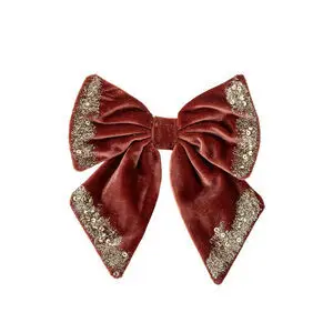 Dekorativ rød sløjfe med glitrende palietter langs kanterne, fyldig og struktureret form.