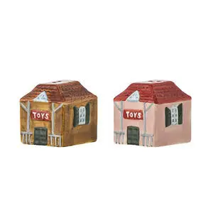 To husformede salt- og peberbøsser, én brun og én lyserød, med "TOYS" og huller på toppen.