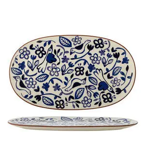 Oval serveringsfad med fugle- og blomstermønster i blå og sorte nuancer, flad profil, let hævet kant.
