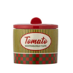 Beholder med farverige striber og tern, rød låg, tekst "Tomato" og "Mediterranean Taste".
