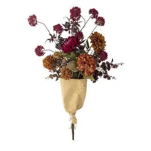 Kunstig buket med orange og røde blomster, indpakket i brunt papir med snor, tæt arrangeret.