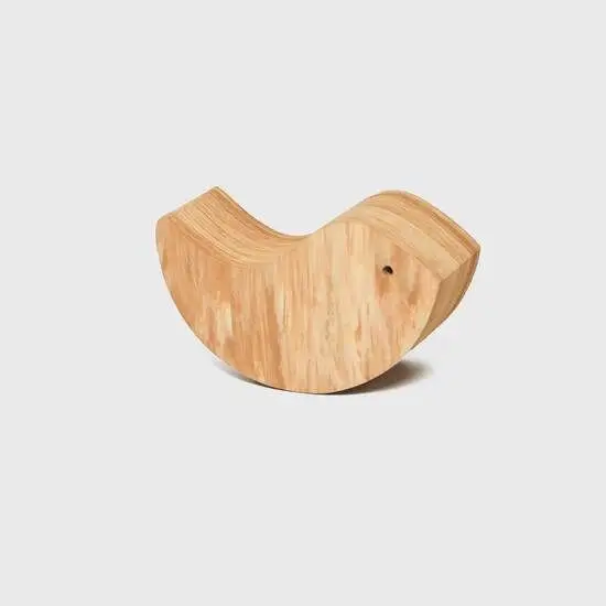 Lille trælegetøj formet som en hval med glat, buet design og markeret øje.