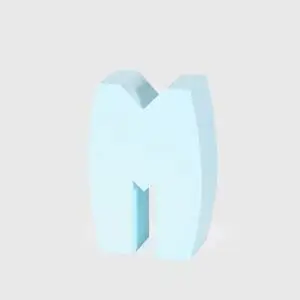 Lyseblåt, tredimensionelt bogstav "M" med glat overflade, stående oprejst på lys baggrund.