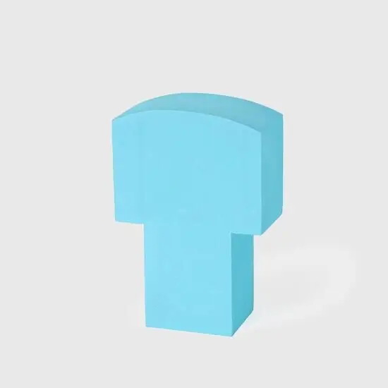 Lys blå skumfigur formet som bogstavet "T", med glat overflade på hvid baggrund.