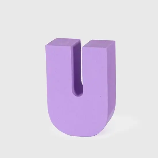 Tredimensionelt, lilla bogstav "U" med flad base, står frit mod en ensfarvet baggrund.