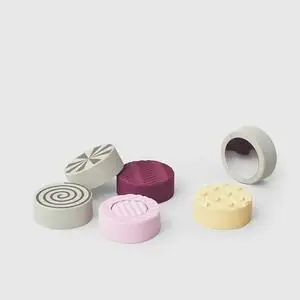 Runde Bobles - Sense Stones i grå, pink, lilla, gul med forskellige mønstre og teksturer.