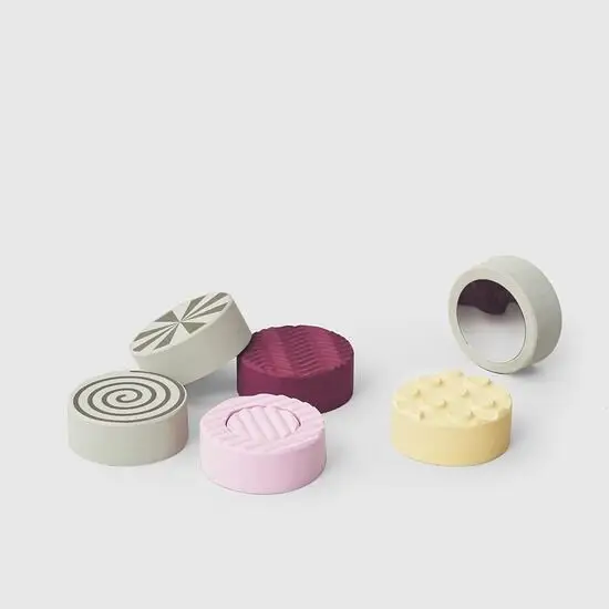 Runde Bobles - Sense Stones i grå, pink, lilla, gul med forskellige mønstre og teksturer.