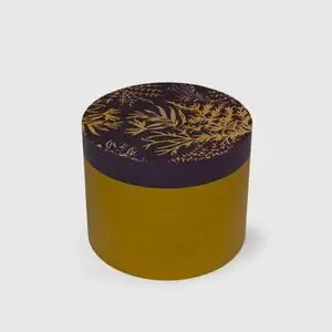 Cylinderformet genstand med guldblomstermønster på mørk top og sennepsfarvede sider.