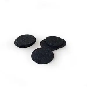 Runde, mørke prikker til dekoration, ligger i en lille bunke på en hvid baggrund.