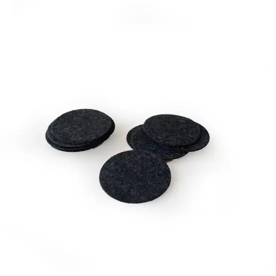 Runde, mørke prikker til dekoration, ligger i en lille bunke på en hvid baggrund.