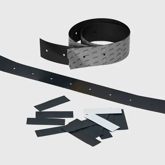 Sort strimmel med huller og klæbende bagside, samt rektangulære magnetstykker.