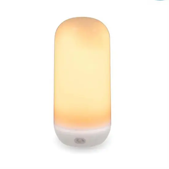 Cylindrisk bordlampe med hvid base og varm, blød glød.