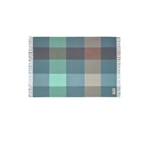 Tæppe med store firkanter i blå, teal og grå nuancer, frynser på kanter og et lille mærke i hjørnet.
