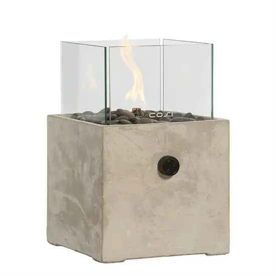 Firkantet cementlanterne med glas, flamme og små sten i bunden.