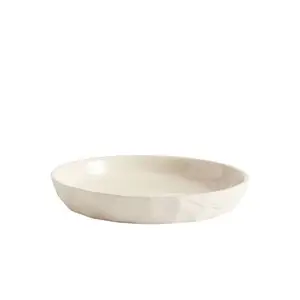 Sandfarvet desserttallerken med uregelmæssig form, glat overflade og let hævet kant.