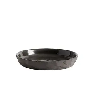 Mørk desserttallerken med glat overflade, tekstureret kant og uregelmæssig form.
