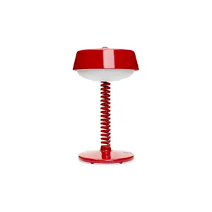 Rød bordlampe med moderne design, fjederformet stander og rund base samt skærm.