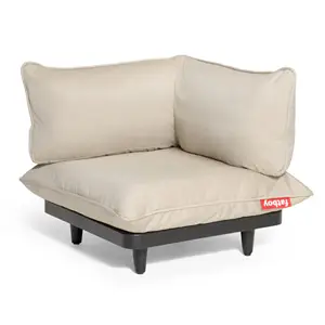 Hjørnesæde med beige hynder, rød "Fatboy" etiket, sort base og korte ben.