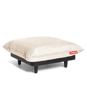 Firkantet puf med lys beige pude, sort base med ben og rød "Fatboy" etiket på puden.