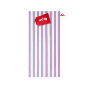 Strandhåndklæde med lilla/hvide striber og rød pude med "fatboy" logo.