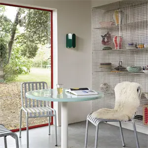 Rundt bord med keramisk top, to stole i mint og galvaniseret design. Indendørs med udsigt til have.