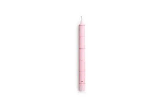 Lys pink cylinderlys med rødt gittermønster og væge. Mærket "Hay" nær bunden.