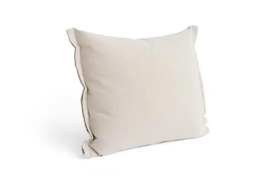 En pude med let tekstureret overflade i neutral sandfarve og enkelt design.