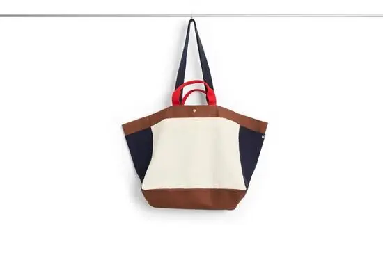 Medium weekendtaske i creme med brune, mørkeblå og røde detaljer. To håndtag og rummeligt design.