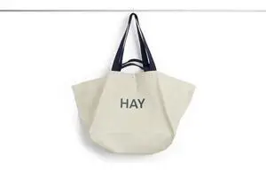 Stor grå weekendtaske med sort håndtag og teksten "HAY" på forsiden.