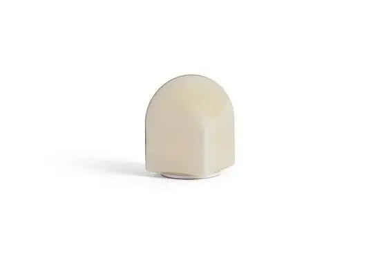 En bærbar lampe i skalmalet hvid, buet top og flad base, 16 cm høj. Minimalistisk design.