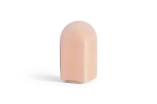 En bærbar lampe i en blød, blush pink farve med en enkel, rundet form. 24 cm høj.