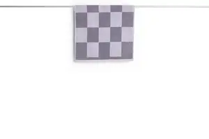 Lavendel ternet bademåtte hænger over en stang. Den har et enkelt design med skakternmønster.