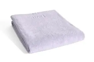 Lavendelfarvet badehåndklæde, blødt og foldet pænt. Enkel og elegant tekstur.