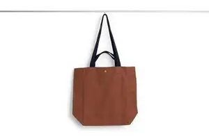 En mellemstor tote taske i mælkechokoladefarve med sorte håndtag. Enkel og stilfuld design.