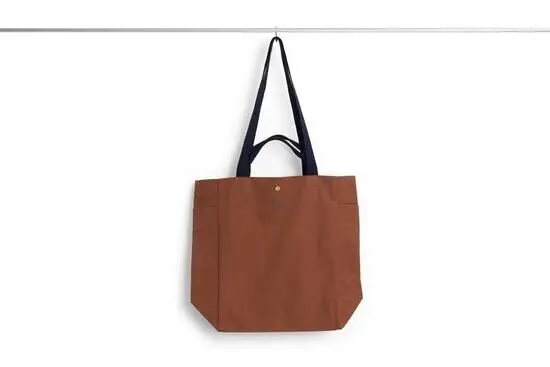 En mellemstor tote taske i mælkechokoladefarve med sorte håndtag. Enkel og stilfuld design.