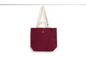 Burgundy tote med beige stropper. Enkel og stilren med teksten "HAY" på forsiden.